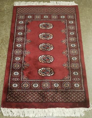 *ORIENTAL RUG: Having burgundy ground with multi colored geometric design, fringe on both ends, approximate size 4' 3" x 2' 10".
