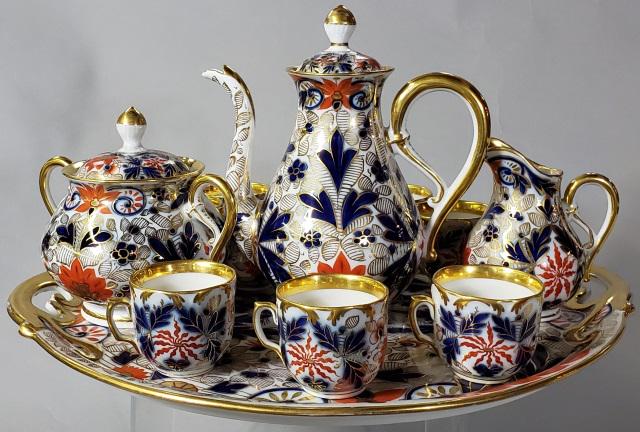 FISCHER & MIEG TEA SERVICE: Comprising 2-handled tray, teapot, covered sugar, creamer, and 9 cups, impressed on underside of tray "F&M", having blue and orange floral decoration.