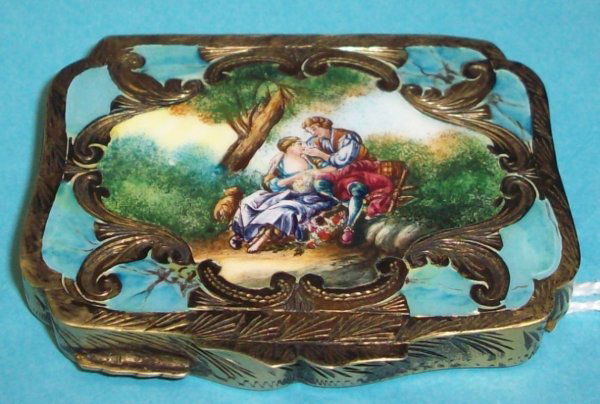 ***COPPINI & C. GILT SILVER AND ENAMEL PETITE POW: The back having repousse scrolled branch design, the lid enameled with romantic forest scene depicting courting couples, the interior bearing makers mark and mirror, approximate width 2 1/4".