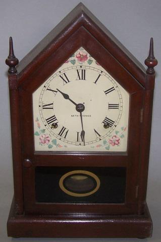 *SETH THOMAS MANTEL CLOCK: Having metal dial, with Roman numeral markers, enclosed in steeple case, with pendulum and key, approximate height 14 1/2", width 9 1/2", depth 4 3/4".