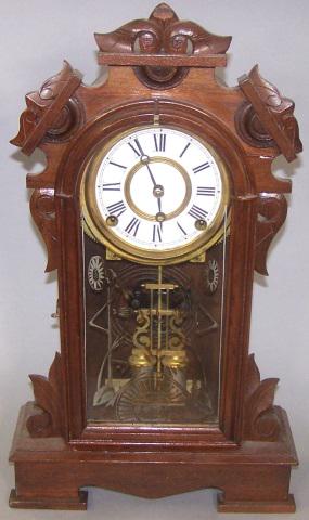*VICTORIAN MANTEL CLOCK BY ANSONIA: Having time and strike movement, painted metal dial, Roman numeral markers, enclosed in walnut case, with pendulum and key, approximate height 19", width 11", depth 4 3/4".