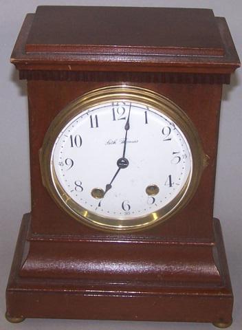 *SETH THOMAS MANTEL CLOCK: Fitted with time and strike movement, having painted metal dial, Arabic numeral markers, enclosed in mahogany case, with pendulum and key, approximate height 10 3/4", width 8 1/2", depth 5 1/2".