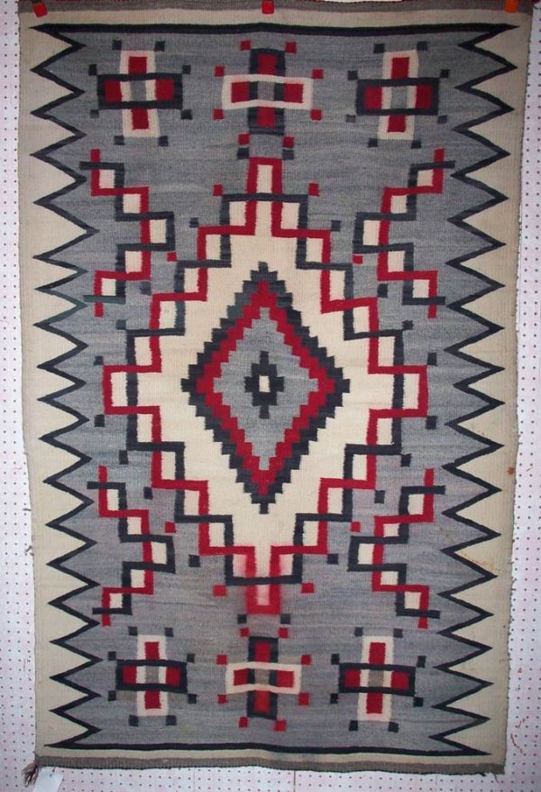 ***NAVAJO WEAVING: Having large serrated diamond central motif in colors of red, black, grey, and white, approximate size 74" x 46".