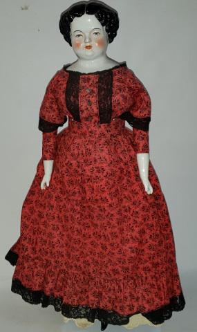 *CHINA HEAD DOLL: Having black hair with painted features, on cloth body with porcelain arms and leg with painted on boots, approximate height 24 1/2".