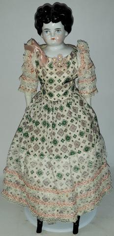 *CHINA HEAD DOLL: Having black hair with painted features, on cloth body with porcelain arms and leg with painted on boots, approximate height 19".