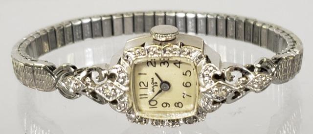 *BULOVA 14K LADIES WRIST WATCH: Bulova 14k white gold and diamond wrist watch, 8 small diamonds surrounding face, and 2 diamonds on either side.