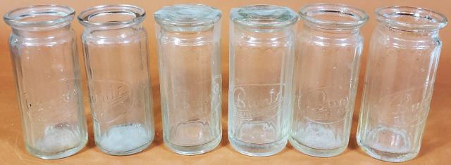 6 BUNTE CANDY JARS: 6 embossed Bunte Candy jars, approximate height 4 1/4", 2 with lids.