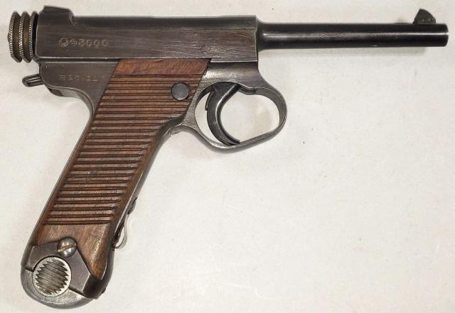 WWII JAPANESE NAGOYA PISTOL: Circa 1930 Pistol, World War II. Japanese "Nambu Type 14", 8mm automatic, S/N 3000, wooden grip with horizontal grooves, blue steel frame, chamber, barrel, and trigger guard. Loaded from clip in grip 