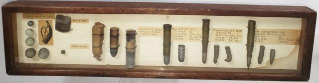 DISPLAY OF BULLET TYPES: Circa 1861, Display of bullet types, in wooden box, with glass front, includes musket balls, mini bullet, 45/70 Springfield bullet, Krag bullet, and .03 Springfield bullet, also percussion cap and gun