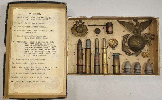 COLLECTION OF WAR RELICS: Varied dates, Collection of war relics wired into box, typewritten list glued inside lid identifies each, 1) Spanish cap badge, 2) large Marine Corps cap badge, 3) Powder measure, 4) Chinese cartridge