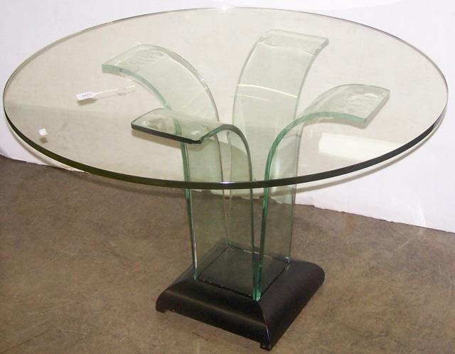 CONTEMPORARY GLASS TOP DINING TABLE: Having 4 curved glass legs and ebony plinth base, approximate height 30", diameter 48".