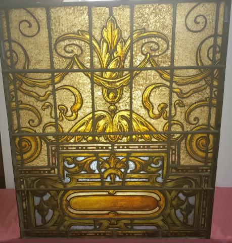 STAINED GLASS WINDOW: Stained glass window, having scroll design, housed in a heavy lead frame, with glass front, approximate height 35", width 29 1/4", depth 1 3/4".