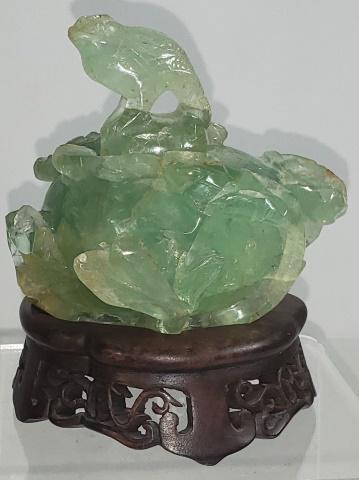 ORIENTAL GREEN QUARTZ SCULPTURE: Jade colored sculpture, with floral design, with animal figural lid and raised on carved fitted wood base, approximate total height 5".