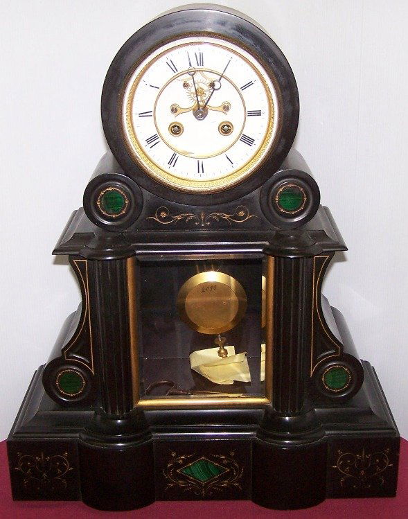 ***FRENCH BLACK SLATE MANTEL CLOCK: Having key wound movement with Roman numeral markers on a white finish dial and contained in a black slate architectural style case with green malachite inlay, approximate height 18 1/2'', width 15'',