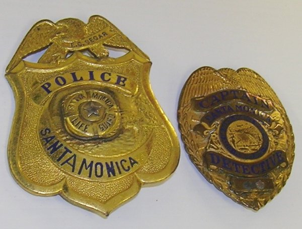 ***SEGAR, ELZIE CRISLER| Two badges: ***SEGAR, ELZIE CRISLER| Two badges, "Captain Santa Monica Detective", reverse stamped Centenmann, Los Angeles, second badge marked "E. C. Segar Police Santa Monica, Santa Monica Life Guard", comes wi