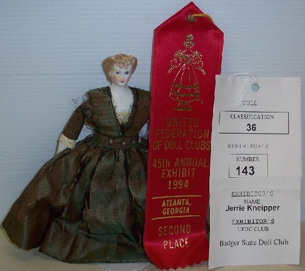 PARIAN DOLL: Having brown hair, braided with forehead curls, molded blouse, cloth body with china arms and legs, and painted button boots, has 2nd place ribbon from 1994, comes from the estate of Geraldine (Jerrie