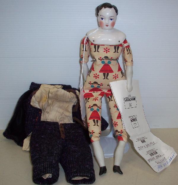 CHINA HEAD DOLL: Man with blue eyes and black hair, on cloth printed body, having bisque half-arms and legs with ribbed stockings and painted boots, comes from the estate of Geraldine (Jerrie) Kneipper, Kenosha, WI, m