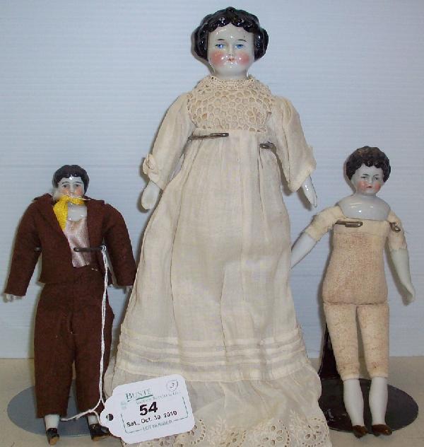 THREE CHINA HEAD DOLLS: All having black hair and cloth bodies with porcelain half-arms and legs, and painted boots, come from the estate of Geraldine (Jerrie) Kneipper, Kenosha, WI, member of ''The Badger State Doll Club'',