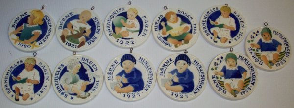 ***ELEVEN ROYAL COPENHAGEN ALUMINIA FAIENCE CHILD: ***ELEVEN ROYAL COPENHAGEN ALUMINIA FAIENCE CHILDREN'S AID DAY CHRISTMAS ORNAMENTS| 1920-1923, two 1925, 1926, two 1927, and two 1928.