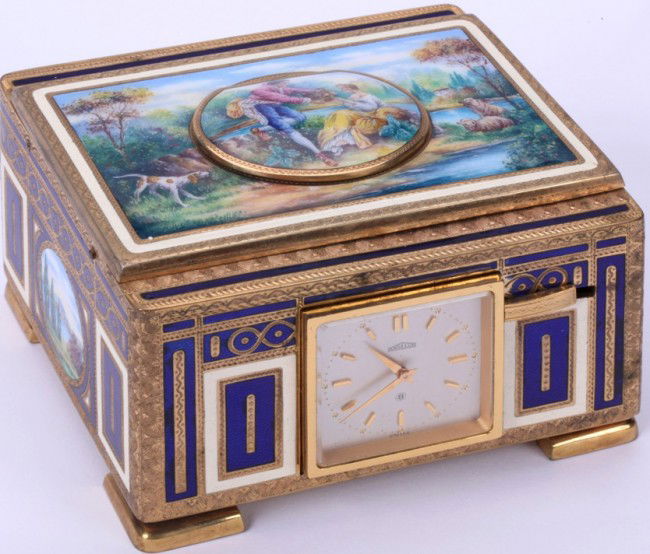ANGELUS CLOCK/MUSIC BOX: Fitted with Swiss 8-day clock movement and singing bird box automaton, contained in an enameled gilt metal case, having figural animal and landscape decoration, approximate height 2 1/2'', width 4'',