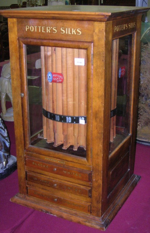 ***POTTER'S SILK SPOOL CABINET: Fitted with single glazed door, opening to revolving interior and 3 drawers below, approximate height 32 3/4'', width 18 1/4'', depth 18 1/2''.
