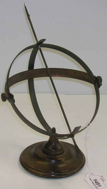 ***EARLY NINETEENTH CENTURY DESKTOP ADJUSTABLE BR: ***EARLY NINETEENTH CENTURY DESKTOP ADJUSTABLE BRASS SUNDIAL| Having arrow finial gnomon, mounted to turned wood base, approximate diameter 6 1/2'', arrow length 10 1/2''.