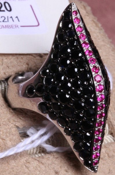 ***STEPHEN WEBSTER 18K WHITE GOLD RING: Set with numerous round cut black sapphires and round cut rubies, marked ''SW'' with English hallmarks, approximate weight 9.80 dwt.