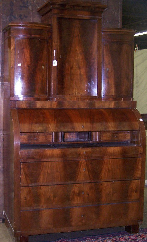 ***NINETEENTH CENTURY BIEDERMEIER MAHOGANY SECRET: Upper section fitted with concave door flanked by convex doors, lower section having cylinder roll opening to fitted interior with 3 drawers below, approximate height 79 1/2'', width 45 1/2'', depth 2