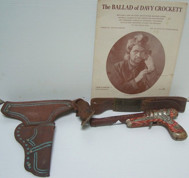 ***FOUR DAVY CROCKETT TOYS: Line Mar Toys tin pistol, leather holster, leather belt with Davy Crockett brass belt buckle and ''The Ballad of Davy Crockett'' sheet music.