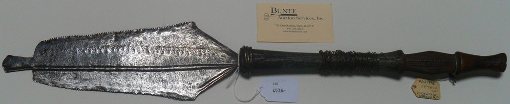 ***EDGED WEAPON: Iron, wood and brass, iron blade with brass wrap around carved wooden handle, approximate height 24'', deaccessioned from Columbus Museum of Art.