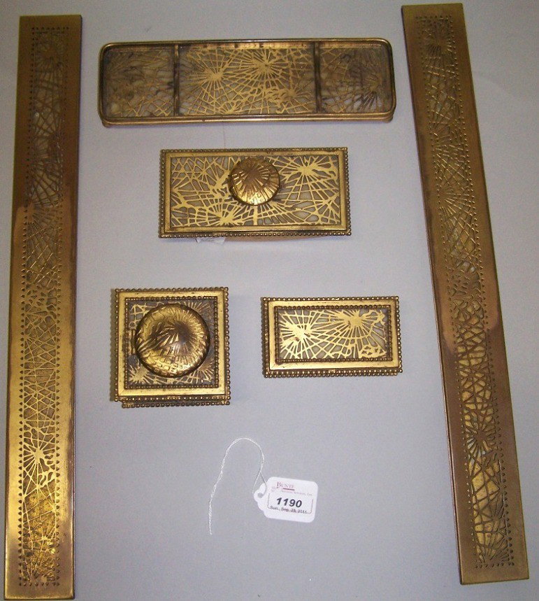 ***TIFFANY STUDIOS NEW YORK GRAPEVINE DESK SET: ***TIFFANY STUDIOS NEW YORK GRAPEVINE DESK SET| Comprising pair of blotter ends, stamp box, inkwell, rocking blotter and pen tray, all in gold dure finish, all signed "Tiffany & Co., New York".