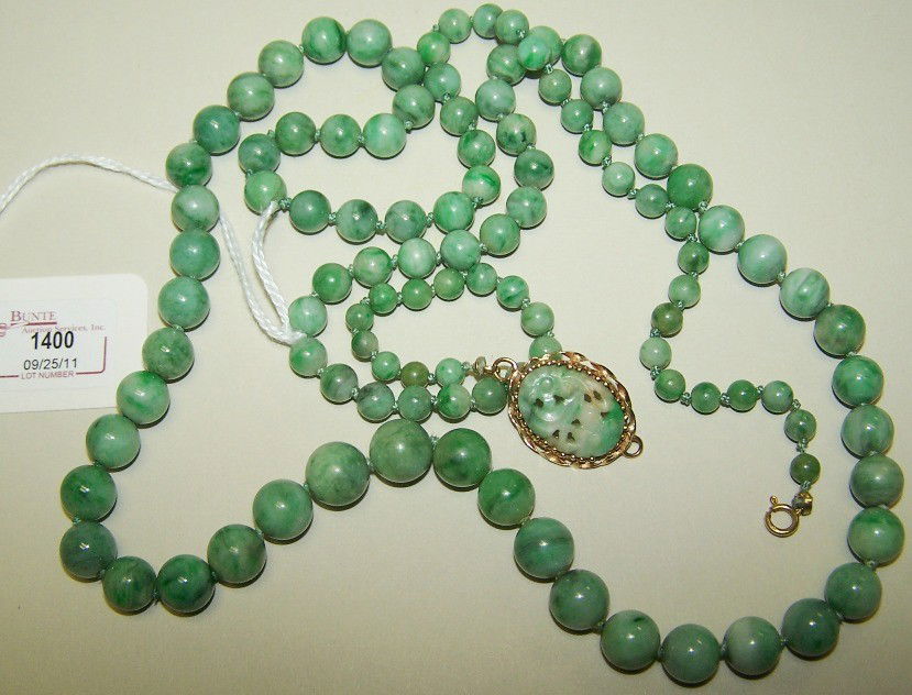 ***CHINESE GREEN JADE BEAD NECKLACE: Composed of jade beads measuring approximately 4.80mm to 9.9mm, set with yellow gold clasp with 1 oval carved and pierced jade stone, necklace length 34''.