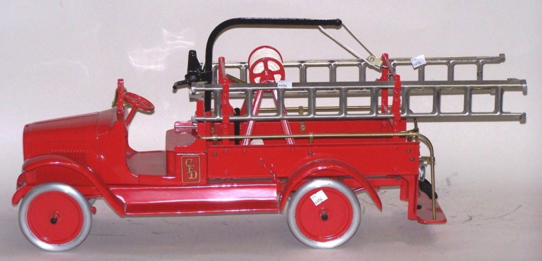 ***BUDDY L HOOK AND LADDER TRUCK: Made of pressed steel, having low back open cab, brass bell, 4 side ladders, brass rail bed, operational boom and steering, steel wheels, approximate length 30''.