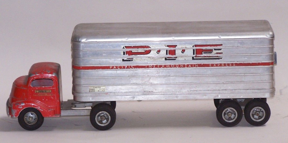 ***SMITH-MILLER P.I.E. TRACTOR TRAILER: Having GMC 6-wheeled cab, aluminum Pacific Intermountain Express trailer with 2 rear doors and 8 wheels, approximate length 23 1/2''.