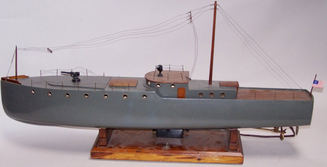 ***VINTAGE WOODEN BOAT MODEL: On electrified wooden display stand, having gloss gray finish with wooden textured deck pieces, cast metal forward deck gun, searchlight on upper deck, deck hatch removable to reveal internal electron