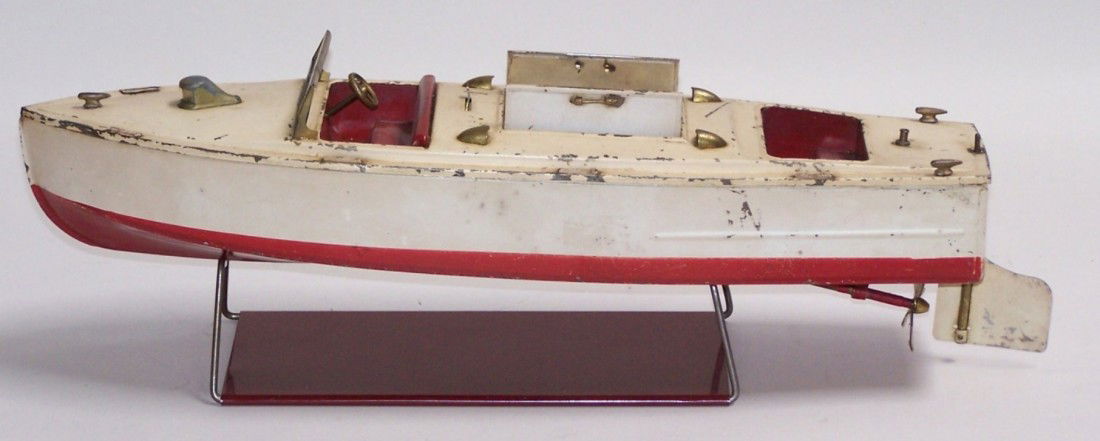***LIONEL-CRAFT TIN WIND UP TOY BOAT: Having deck doors opening to reveal clockwork wind-up motor, steerable rudder, approximate length 17''.