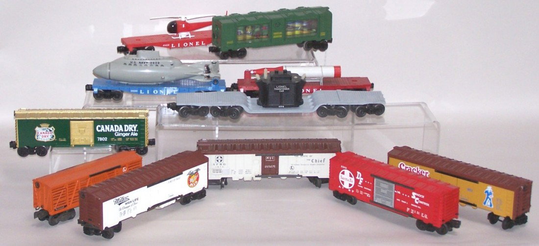 ***11 PIECES LIONEL ROLLING STOCK: O gauge, including #3435 traveling aquarium, #9853 Cracker Jack box car, #7802 Canada Dry box car, #3656 operating cattle car with 5 cattle figures, #9852 Miller High Life box car, #6518 Transformer c
