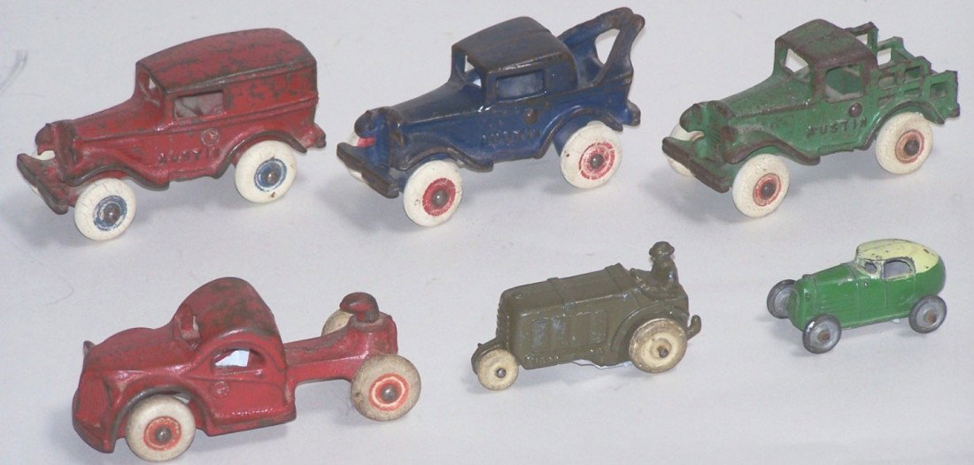 ***6 CAST IRON AND SLUSH TRUCKS: Arcade Austin delivery truck, stake truck and wrecker, approximate length each 3 3/4'', Arcade truck tractor, C.A.W. Midget Coupe racer, length 2 1/8'', and Barclay army tractor.