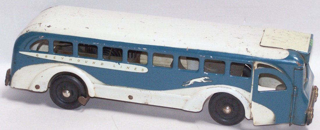 ***BUDDY L WIND UP GREYHOUND BUS: Having Greyhound Lines decals on sides and rear, ''Buddy L'' on placard above windshield, wind up clockwork motor and red electric light on rear, posable steering, approximate length 16''.