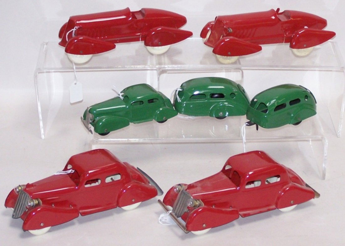 ***7 WYANDOTTE PRESSED STEEL VEHICLES: 2 Boat tail racers with rubber wheels, approximate length 9'', two #334 four-door sedans with rubber wheels, length 9'', coupe and trailer combo, combined length 11'', and 1 Airstream trailer, length 