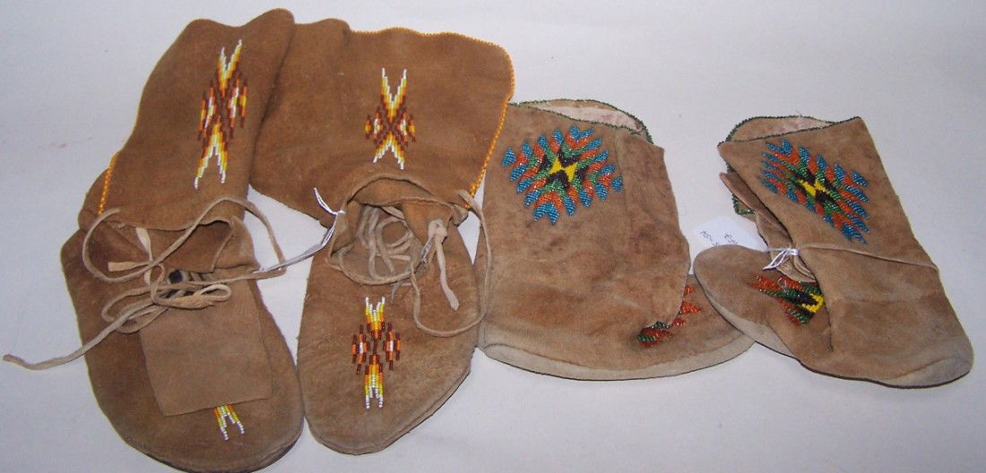 ***TWO PAIR BEADED HIDE BOOTS: Beaded with multicolor geometric design, approximate length 7 3/4'', height 10'', and length 10 1/4'', height 12''.