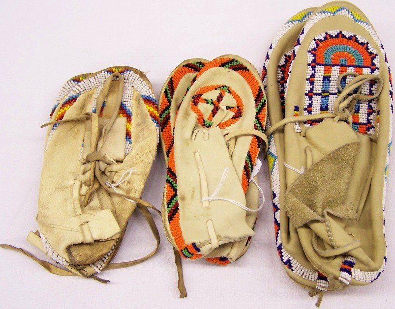 ***THREE PAIR CHEYENNE MOCCASINS: Commercially tanned leather, beaded with multicolor geometric designs, approximate length of longest 11''.