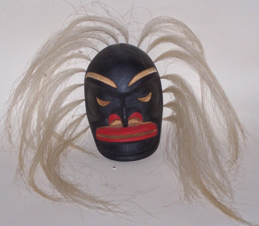 ***WOOD CARVED MASK: False face style, decorated with horsehair and black and red paint, approximate size with hair 16'' x 8''.