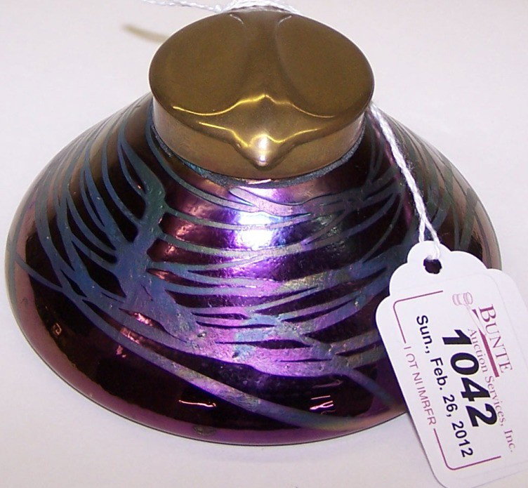 ***LOETZ ART GLASS AND METAL INKWELL: Having iridescent purple stringing decoration, fitted with gilt metal collar and lid, approximate height 2 1/4'', diameter 4 1/4''.