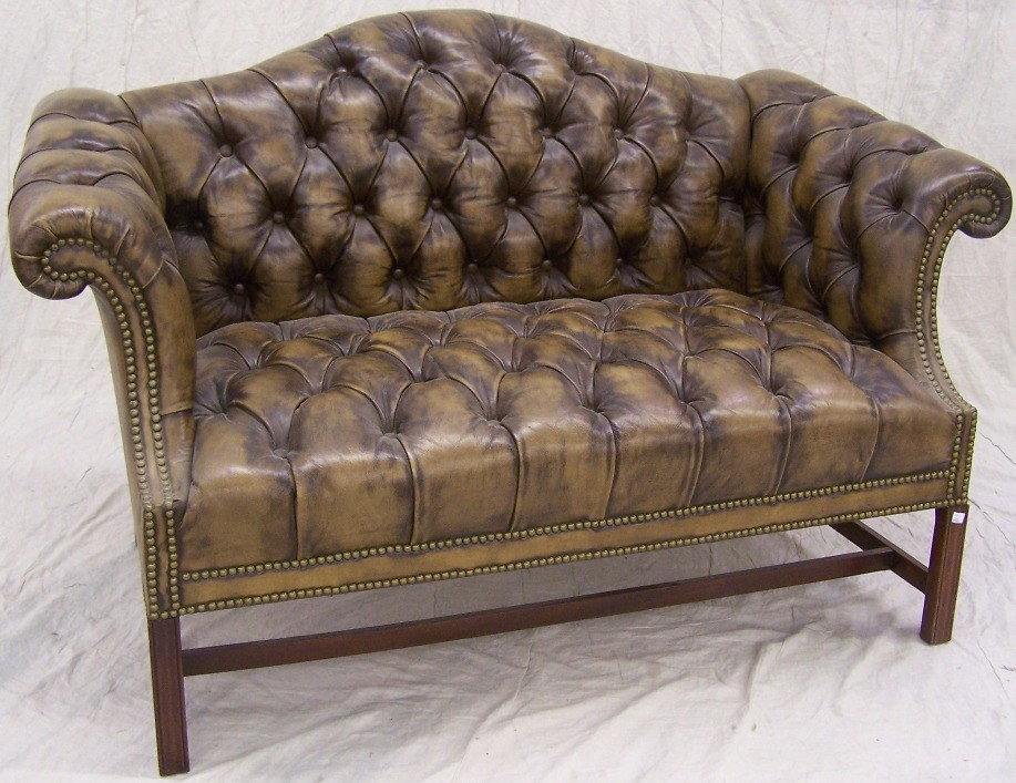 ***GEORGIAN STYLE CAMELBACK SETTEE: Having brown tufted upholstery, raised on square legs, approximate height 35'', width 56'', depth 32''.