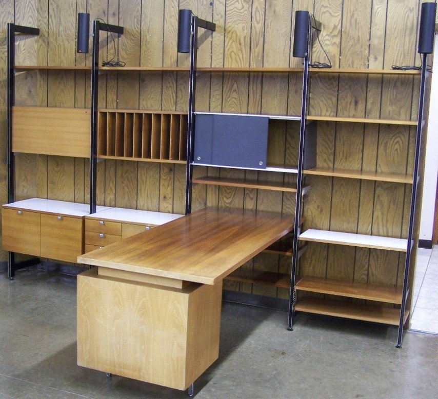 ***GEORGE NELSON/HERMAN MILLER CSS UNIT| With de: ***GEORGE NELSON/HERMAN MILLER CSS UNIT| With desk to form L-shape, having open shelves, cubbyholes, drawers, sliding doors and 4 canister lights, approximate height 84", width 128", depth 73".