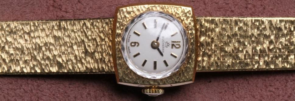 ***LADY'S BUCHERER 14K YELLOW GOLD WRISTWATCH: Having jeweled movement, stem wound and set, with Arabic and bar markers on white finish dial, contained in 14K yellow gold case and fitted with 14K yellow gold straps, approximate weight 26.2 dwt.