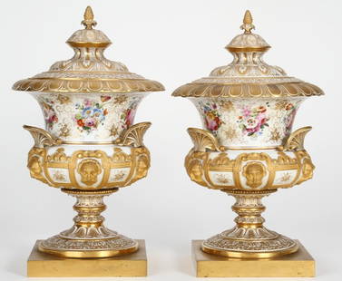 ***PAIR OF 19TH C. RUSSIAN COVERED URNS: Having hand painted floral and leaf decoration, further enhanced with gilt mask decoration and highlight, raised on gilt bronze base, approximate height 16 1/2''.