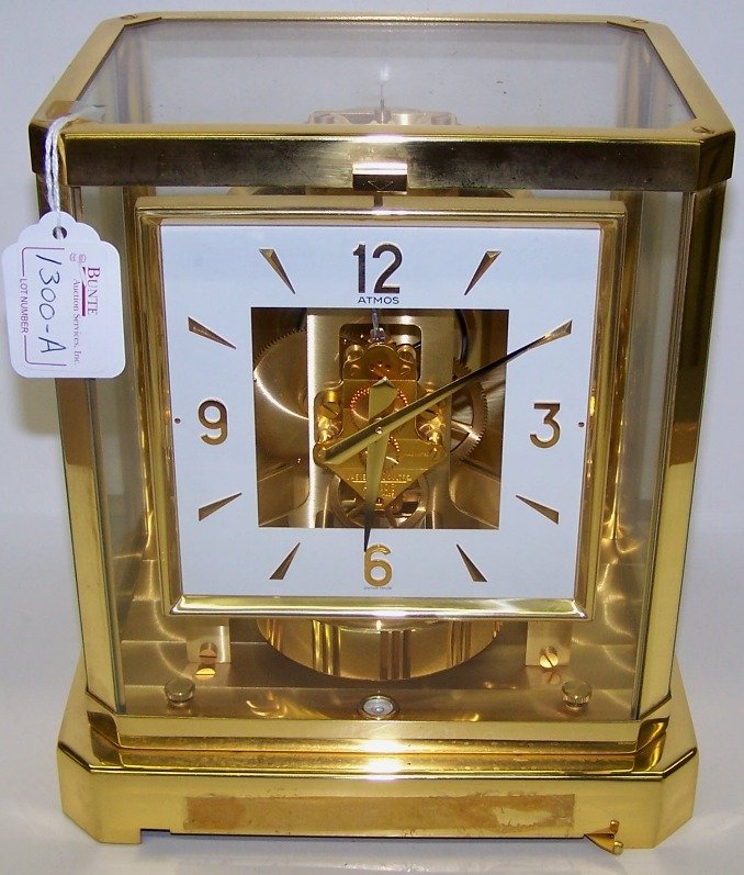***LECOULTRE ATMOS CLOCK: Having 15 jewel movement, with Arabic and bar markers on white finish dial, contained in brass and glass case, approximate height 9 1/4''.