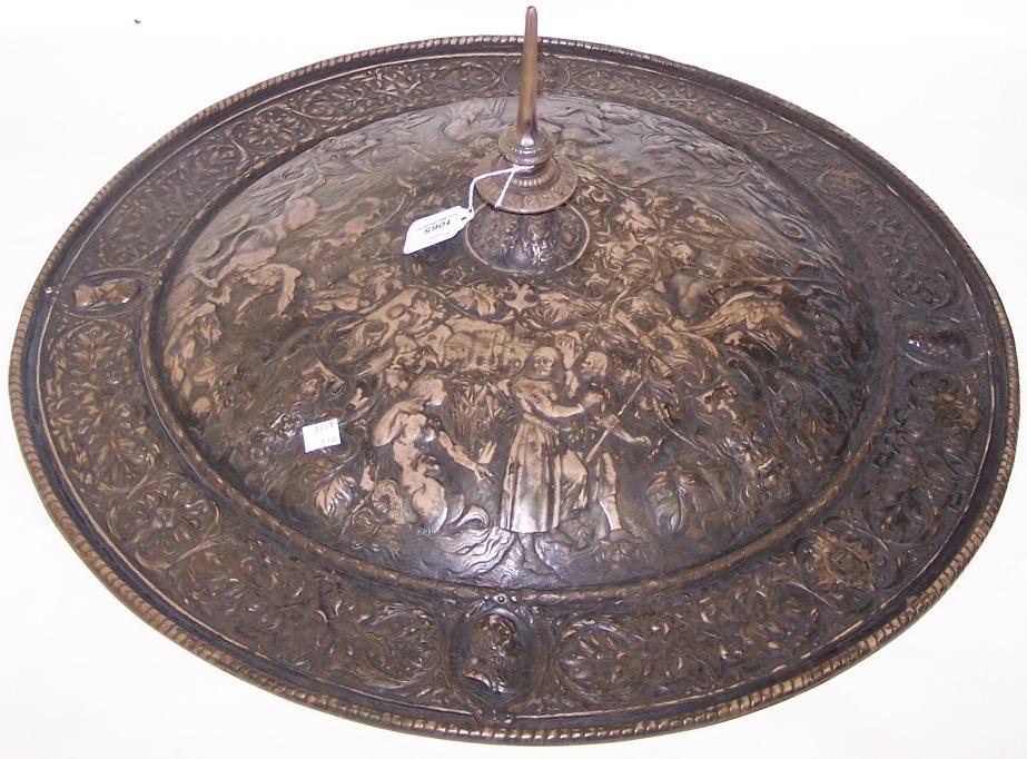 ***ELKINGTON SILVERPLATE SHIELD: Having relief decoration depicting demon masks, St. George slaying the dragon, temptation of St. Thomas, mythical beasts, scrollwork, etc., the border decorated with 4 portraits, approximate diameter 